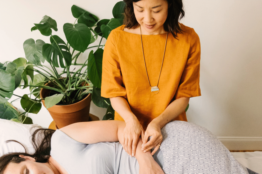 Sharon Yeung from Five Seasons Healing performing acupuncture on a woman