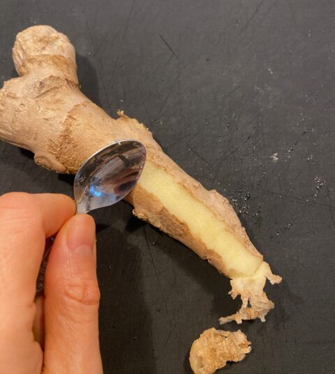 peeling ginger with a spoon for Traditional Chinese congee recipe