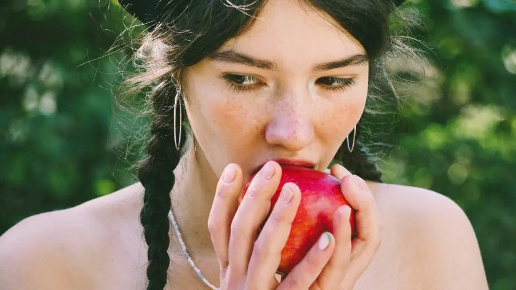 Close-up of woman eating an apple depicting TCM Snack Ideas: A Holistic Guide to Traditional Chinese Medicine-Inspired Snacks